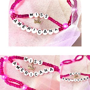 This "Miss Americana" bracelet, inspired by Taylor Swift, features vibrant pink beads and pearls, with a crown charm symbolizing her iconic status. handcrafted accessory celebrating the spirit of Swift's music and is perfect for fans and collectors.