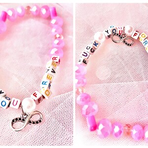 Embrace the fierce spirit of Taylor Swift’s *folklore* with this pink beaded bracelet, featuring an infinity sign charm, inspired by the line "f*ck you forever" from "Mad Woman." A perfect symbol of strength and enduring resilience for any Swiftie.