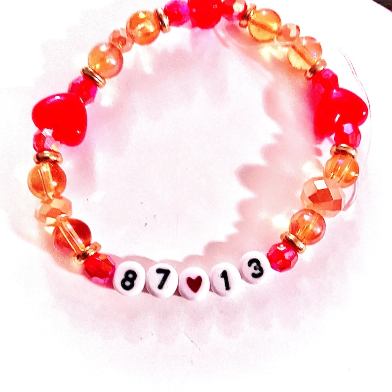 Handmade “87❤️13” friendship bracelet inspired by Taylor Swift and Travis Kelce featuring red and gold beads with heart details on elastic stretch cord. Romantic football-inspired bracelet celebrating Travis Kelce’s jersey number 87 and Taylor Swift’s lucky number 13. Perfect for Swifties, football fans, concert outfits, friendship bracelet trading, bracelet stacks, and pop culture inspired accessories.