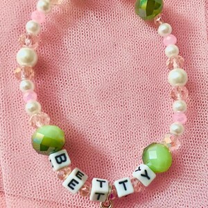 This pink and green beaded bracelet inspired by Swift's "Betty," reflects the song's youthful charm and storytelling essence. for Swifties, it beautifully embodies the nostalgia of *Folklore making it a perfect accessory for fans and collectors alike