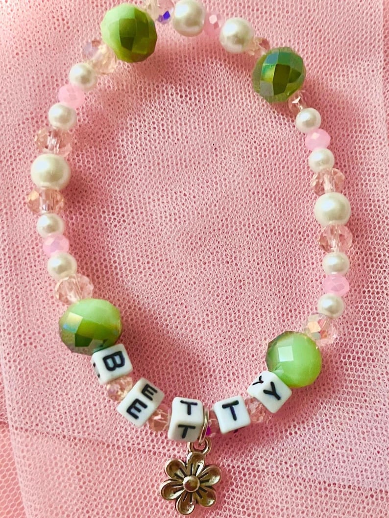 This pink and green beaded bracelet inspired by Swift's "Betty," reflects the song's youthful charm and storytelling essence. for Swifties, it beautifully embodies the nostalgia of *Folklore making it a perfect accessory for fans and collectors alike