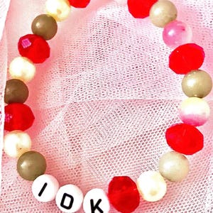 This red, yellow, and green bracelet, inspired by Death by a Thousand Cuts symbolizes the line I ask the traffic lights if it’ll be alright; they say, I don’t know. Great costume for eras tour It captures the song's themes of longing and uncertainty.