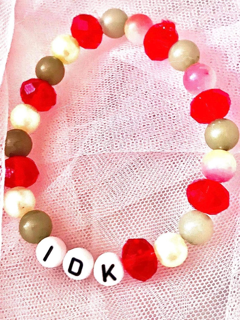This red, yellow, and green bracelet, inspired by Death by a Thousand Cuts symbolizes the line I ask the traffic lights if it’ll be alright; they say, I don’t know. Great costume for eras tour It captures the song's themes of longing and uncertainty.