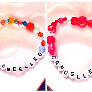 A collage featuring two handmade Taylor Swift The Life of a Showgirl inspired friendship bracelets. Both designs spell “Cancelled!” with letter beads, reflecting the bold album track. One bracelet is bright orange with green/teal accents, while the other is striking red. Crafted with elastic, glass, and plastic beads, these trendy Swiftie bracelets make perfect jewelry gifts, concert accessories, or collectible fan merch from Taylor Swift’s newest era