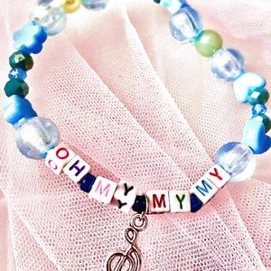 Capture the carefree energy of Taylor Swift's debut album with this blue beaded bracelet, inspired by "Oh My My My." Featuring a music note charm, this bracelet is a perfect tribute to the song's joyful spirit and youthful vibe