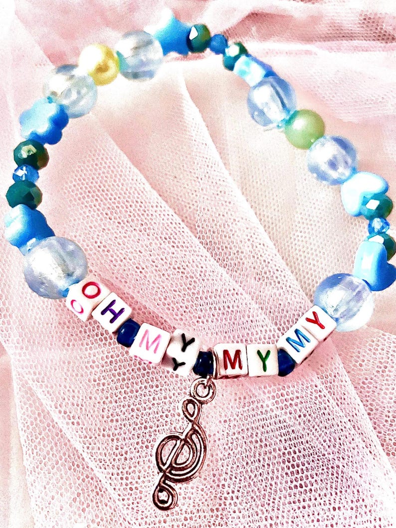 Capture the carefree energy of Taylor Swift's debut album with this blue beaded bracelet, inspired by "Oh My My My." Featuring a music note charm, this bracelet is a perfect tribute to the song's joyful spirit and youthful vibe