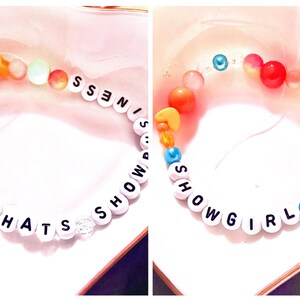 A collage showcasing two handmade Taylor Swift The Life of a Showgirl inspired friendship bracelets. One bracelet features the phrase “Baby That’s Showbusiness”, while the other spells “Showgirl.” Both designs are crafted with bold orange and teal beads, strung on durable elastic with letter beads. Perfect Swiftie jewelry for concerts, gifts, or stacking, these bracelets capture the playful glamour of Taylor’s newest album era and make trendy collectible fan accessories