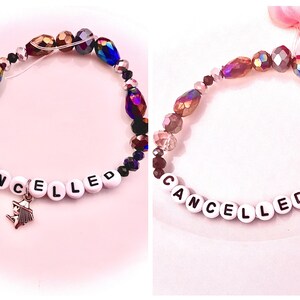 two Taylor Swift–inspired bracelets from The Life of a Showgirl: one reading “Tone Deaf and Hot” and the other “Cancelled.” Inspired by her track five, “Cancelled,” rumored to be about Blake Lively, the bracelets reflect the song’s edgy lyrics “Good thing I like my friends cancelled” and “Tone deaf and hot, let’s f*cking off her.” A perfect tribute to Taylor’s fierce wit, self-awareness, and pop culture commentary, these bracelets embody the drama and confidence of her Showgirl era.