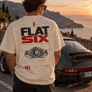 May include: An off-white short-sleeve t-shirt featuring a black and red graphic on the back. The design includes the text "FLAT SIX" and "HORIZONTALLY OPPOSED," a detailed engine illustration, the number "01," and "STUTTGART / ZUFFENHAUSEN" text.