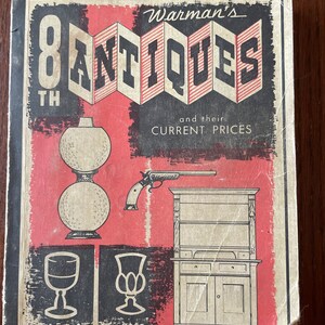 May include: The cover of an 8th edition book titled "Warman's Antiques and their Current Prices" by Edwin G. Warman. The cover features a red background with black and white illustrations of antiques, including a gun, a cabinet, and glassware.