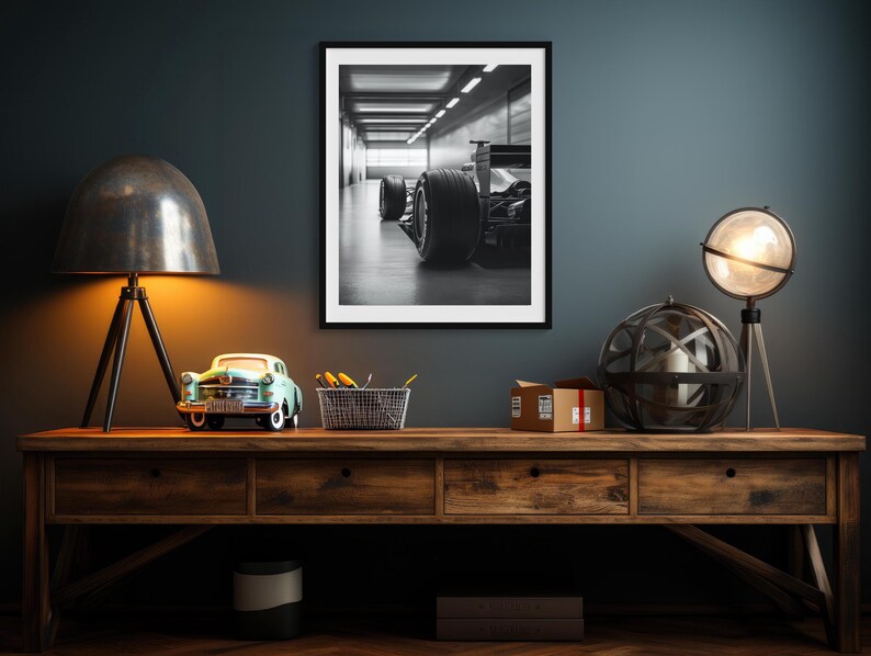 Dramatic black and white art print of a Formula 1 car parked in a well-lit garage, highlighting the precision and allure of high-speed racing. Ideal for car lovers, adding bold style to man caves and home offices. f1 wall art, f1 poster