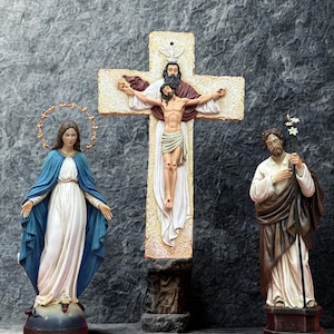 Könnte beinhalten: Religiöse Statuen von Maria, Jesus am Kreuz und Josef. Maria trägt einen blauen Umhang und ein weißes Kleid mit Heiligenschein. Das Kreuz zeigt Jesus und Gott. Josef hält einen Stab mit Blumen.