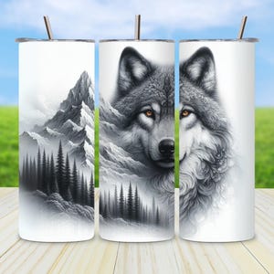Pode incluir: Um conjunto de três canecas de aço inoxidável brancas com um design de lobo e montanha. O lobo é retratado em tons de cinza com olhos âmbar. A cena da montanha é em preto e branco, com uma floresta de árvores.