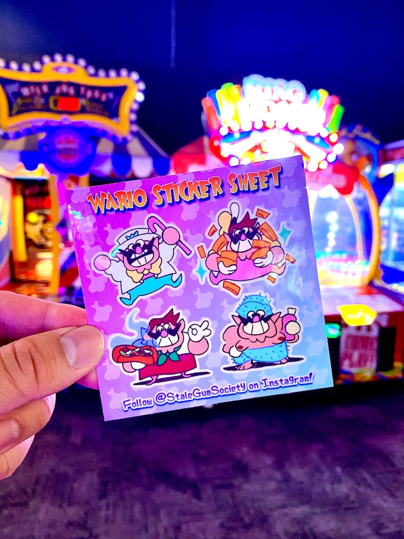 Op de afbeelding: Een vierkant stickervel met een lichtpaarse achtergrond met vier cartoonillustraties van Wario. De tekst luidt WARIO STICKER SHEET bovenaan en Follow @StaleGumSociety on Instagram! onderaan in blauwe en gele letters.