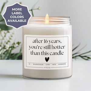 May include: A white candle with a clear glass jar and a label that reads "after 16 years, you're still hotter than this candle".