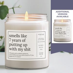 May include: A white candle with a black label that reads "smells like 7 years of putting up with my shit. Infused with endless patience, unconditional love, and a touch of 'you deserve an award.'"