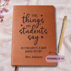 May include: A brown leather journal with the text "The things my students say" and "So I can write a book when I retire." A gold pen rests beside the journal. The journal is personalized with the name "Mrs. Johnson."