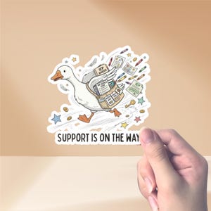 May include: A white goose sticker with orange feet and beak, carrying a bag filled with documents and pencils. The sticker has the text "SUPPORT IS ON THE WAY" and other text including "IEP BINDER" and "IEP GOALS 2024". The sticker is surrounded by stars and coins.