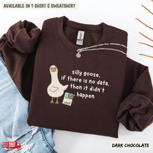 Puede incluir: Sudadera de color chocolate oscuro con el texto "silly goose, if there is no data, then it didn't happen". También presenta un ganso de dibujos animados con gafas y un gráfico. Disponible como camiseta.