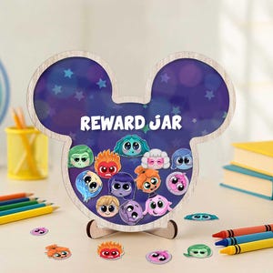 May include: A wooden reward jar in the shape of Mickey Mouse ears, with the words "REWARD JAR" in white. The jar features cartoon character faces and star accents. Includes small character stickers and crayons.