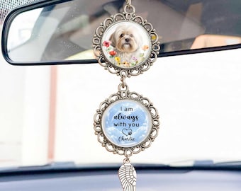 May include: A car charm featuring a Shih Tzu dog portrait surrounded by flowers. Below, a round charm with the text "I am always with you" and a paw print, with the name "Charlie". A silver wing charm hangs below.