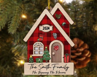 Puede incluir: Adorno navideño con forma de casa de madera con un patrón de cuadros rojos y negros. El adorno presenta una puerta, una ventana, un árbol de Navidad y el año "2024". El texto "The Smith Family New Beginnings New Memories" está en la parte inferior.