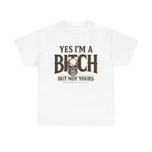 Może przedstawiać: Biały t-shirt z krótkim rękawem z nadrukiem graficznym na klatce piersiowej. Wzór zawiera napis 'YES I'M A' nad słowem 'BITCH', gdzie szczegółowa ludzka czaszka zastępuje literę 'I', a poniżej znajduje się napis 'BUT NOT YOURS'.