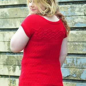 May include: A red knitted sweater with a cable knit pattern. The sweater has a scoop neck and short sleeves.