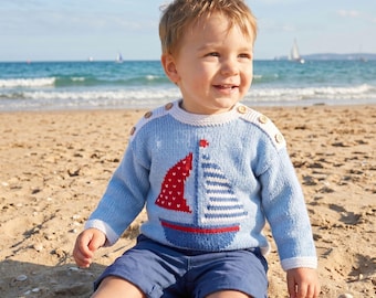 May include: A light blue long-sleeve knit sweater featuring a sailboat graphic with a red patterned sail and white striped sail. The sweater has a round neckline, white ribbed cuffs, and three wooden buttons on each shoulder, paired with navy blue shorts.