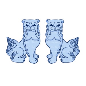 May include: Two blue ceramic foo dogs, traditional Chinese guardian lions, with intricate details and a stylized design. The foo dogs are facing each other, with their heads turned slightly to the side.