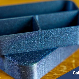 May include: A blue plastic organizer with three compartments. The organizer has a textured, speckled finish.