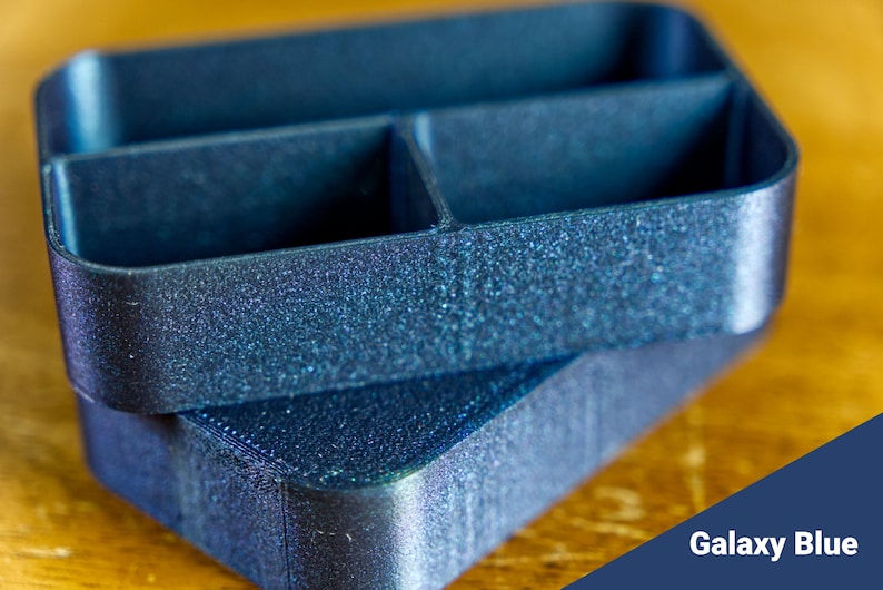 May include: A blue plastic organizer with three compartments. The organizer has a textured, speckled finish.