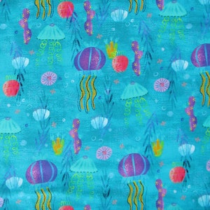 May include: A blue background with a repeating pattern of purple, pink, and blue jellyfish, seaweed, and seashells. The jellyfish have long, flowing tentacles.