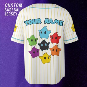 May include: A white baseball jersey with thin yellow pinstripes and light blue trim. The back features the text "YOUR NAME" in blue, surrounded by seven colorful star-shaped characters in blue, red, orange, yellow, purple, green, and black.