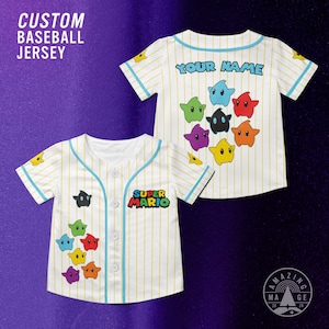 May include: A white baseball jersey with thin yellow pinstripes and light blue trim. The front features the text SUPER MARIO and colorful star characters. The back displays the text YOUR NAME above a cluster of colorful star characters.
