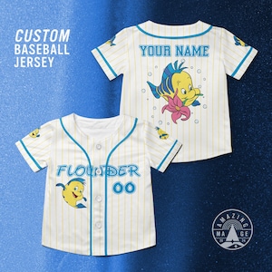 May include: White baseball jersey with yellow pinstripes and blue accents. The jersey features the name "Flounder" and the number "00" on the front, and a cartoon character on the front and back. The text "CUSTOM BASEBALL JERSEY" is on the top left.