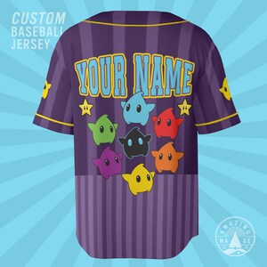 May include: A purple baseball jersey with vertical stripes and yellow trim. The back features the text "YOUR NAME" in light blue, surrounded by colorful star-shaped characters in blue, green, red, black, orange, yellow, and purple.