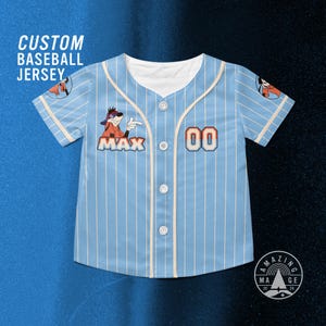 May include: Pale blue baseball jersey with white vertical stripes, displaying the name "MAX" and the number "00". The jersey has a cartoon character patch and the words "CUSTOM BASEBALL JERSEY" are printed at the top.
