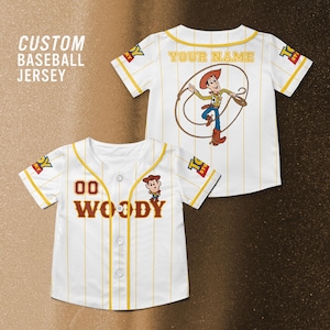 Może przedstawiać: Biała koszulka baseballowa z ż&oacute;łtymi prążkami i akcentami. Z przodu widnieje imię "WOODY" i numer "00" oraz ilustracja postaci z kresk&oacute;wki. Z tyłu koszulki znajduje się ilustracja postaci z kresk&oacute;wki i napis "YOUR NAME".