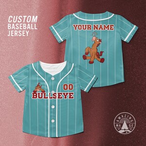 Puede incluir: Camiseta de b&eacute;isbol de color turquesa con rayas blancas, con un gr&aacute;fico de un caballo de dibujos animados. La camiseta tiene el texto "YOUR NAME" en la espalda y "00 BULLSEYE" en la parte delantera. Tambi&eacute;n son visibles las palabras "CUSTOM BASEBALL JERSEY".