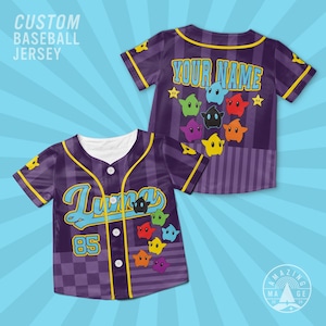 May include: A purple baseball jersey with a button-down front, yellow trim, and a checkered pattern. The front features the text Lumas and the number 85, while the back displays the text YOUR NAME. Both sides feature colorful star characters.