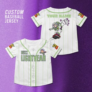 Puede incluir: Dos camisetas de b&eacute;isbol blancas con rayas finas y detalles verdes. Una camiseta presenta "Buzz Lightyear" y un gr&aacute;fico de dibujos animados. La otra tiene "Your Name" y un gr&aacute;fico de Buzz Lightyear. El texto "Custom Baseball Jersey" est&aacute; en la esquina superior izquierda.
