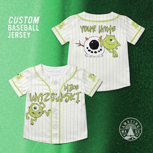 May include: White baseball jersey with green pinstripes and a cartoon character graphic. The jersey features the text "MIKE WAZOWSKI" and "YOUR NAME". The image also includes the text "CUSTOM BASEBALL JERSEY".