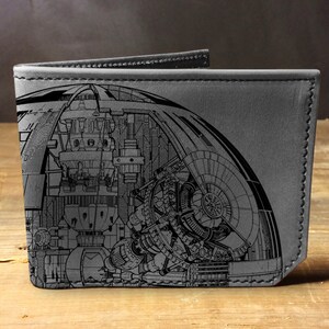 May include: A gray leather wallet with a detailed black and white illustration of a spaceship on the front.