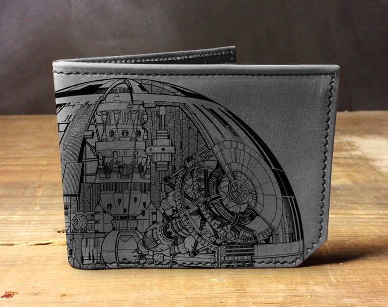 May include: A gray leather wallet with a detailed black and white illustration of a spaceship on the front.