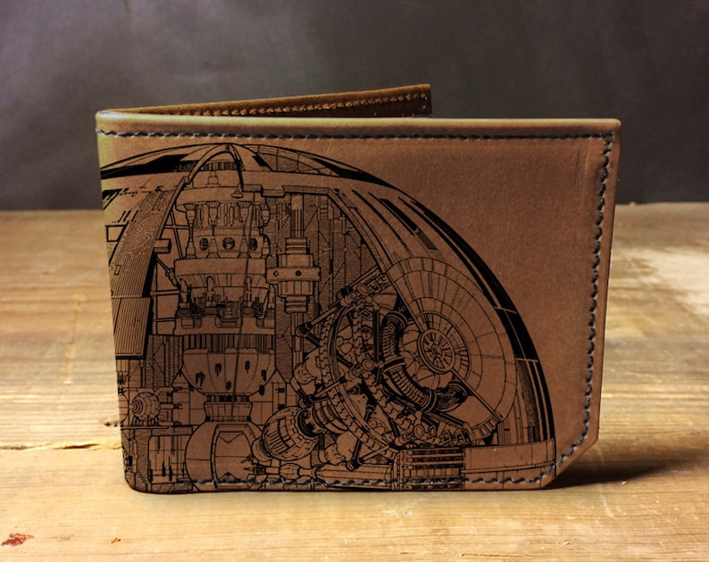 May include: A brown leather wallet with a detailed black and white illustration of a spaceship on the front.