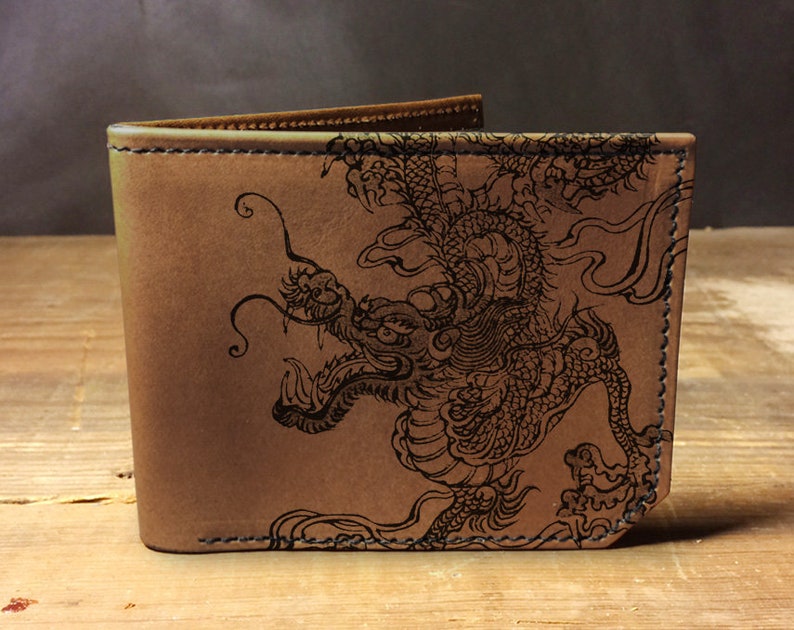 May include: A brown leather wallet with a black dragon design embossed on the front.