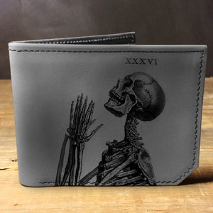 May include: A gray leather wallet with a black skeleton design and the Roman numeral 'XXXVI' printed on the front.