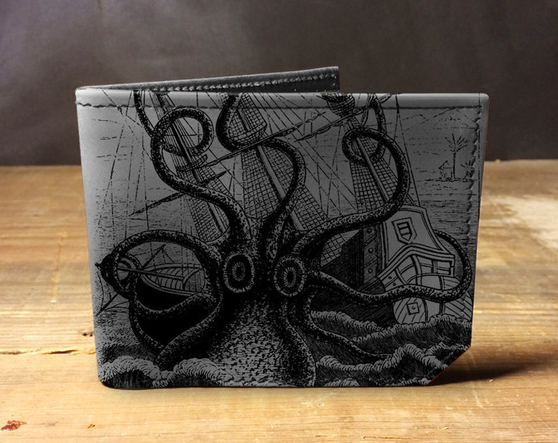 May include: A black leather wallet with a graphic print of a kraken attacking a ship. The kraken is a mythical sea monster with tentacles.