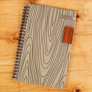 May include: A brown notebook with a black spiral binding and a leather bookmark. The cover has a wood grain pattern and the text "Backerton Handmade in the USA" is printed on the front.
